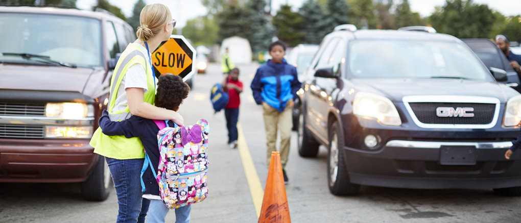 Teacher greets crossing student