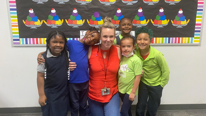 Lindsey Shehu with her arms around her students