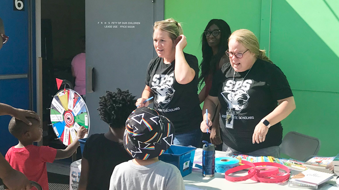 Students spinning a prize wheel. Students spinning a prize wheel.