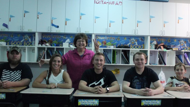 Adults sitting at desks with Mrs Halka.