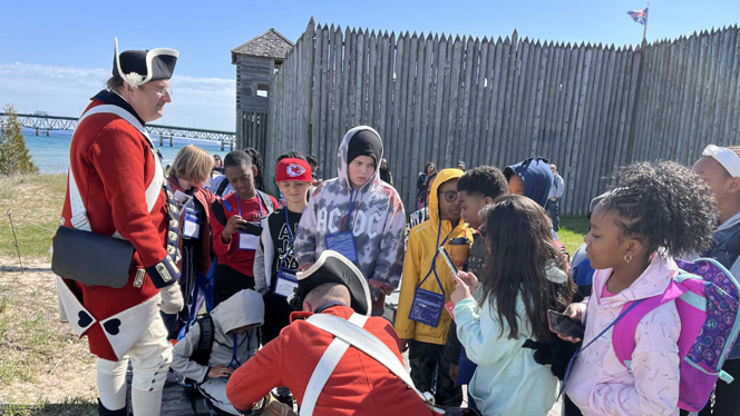Students talking to people dressed in Revolutionary War costumes