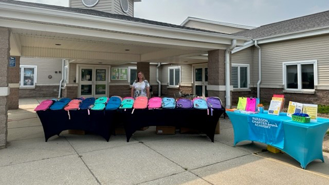 Backpacks lined up on a table.