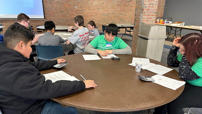 Students writing at tables. Students writing at tables.