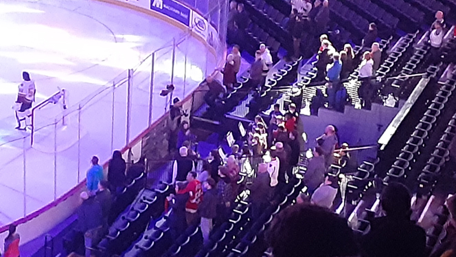 Students playing instruments at a hockey game. Students playing instruments at a hockey game.